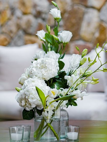 A duplicate of image 195, showing a simple, elegant bouquet of white hydrangeas and orchids on a coffee table in our lounge area. This detail shows how we carry our aesthetic through every space.