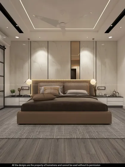 This master bedroom showcases a stunning marble-paneled accent wall and a sliding barn door for the bathroom, combining rustic and luxurious elements.