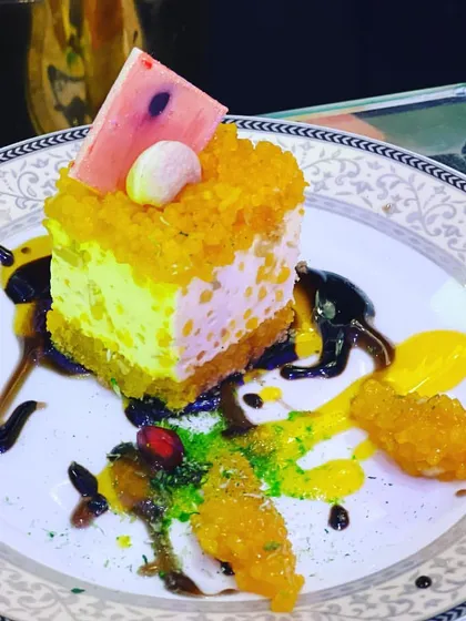 Another example of a vibrant and artistic plated dessert. The combination of a cheesecake-style base with colorful sauces and crumbles makes for a visually exciting and tasty dish.