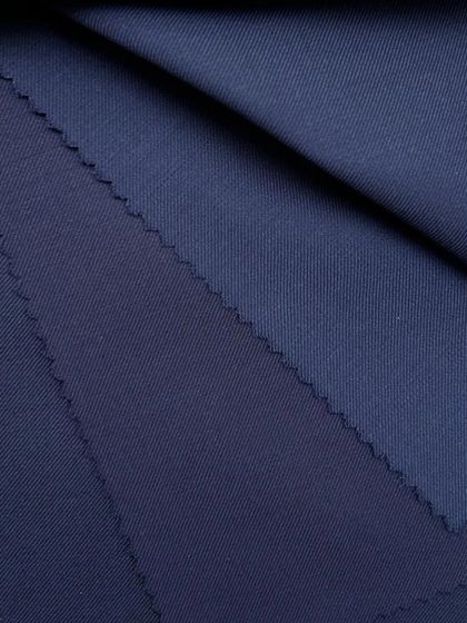 The rich texture and color of our navy wool fabric. This is a perfect choice for a classic blazer or a full suit that exudes authority and style.