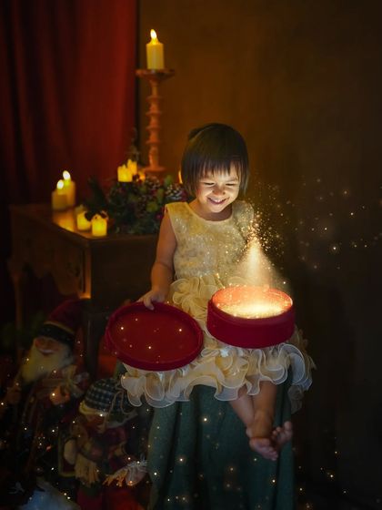 The magic of a Christmas gift box. This little girl's face, lit by the glowing box, is filled with pure wonder and delight. It’s a moment of pure, unscripted magic.