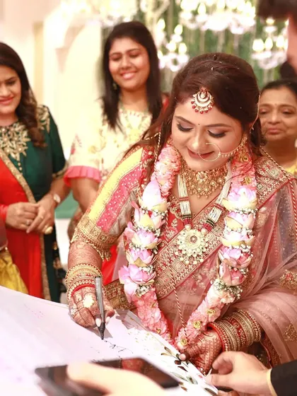 The bride happily signing the contract, surrounded by her smiling new family. It's a moment of pure fun and acceptance.