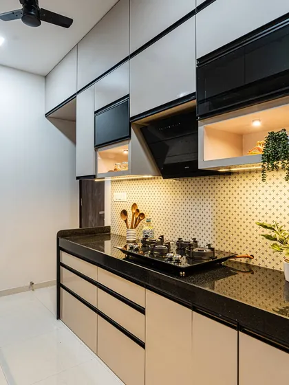 Another angle of this sleek kitchen, showing the chimney hood and the mix of solid and glass-front overhead cabinets. This combination adds visual interest and breaks the monotony.