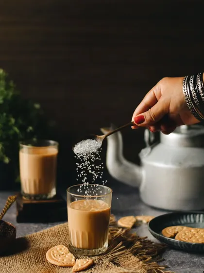 This shot is my ode to *baarish aur chai*. I wanted to capture that simple, perfect moment of adding sugar to a glass of tea, with a rustic, moody backdrop that feels like a rainy afternoon.