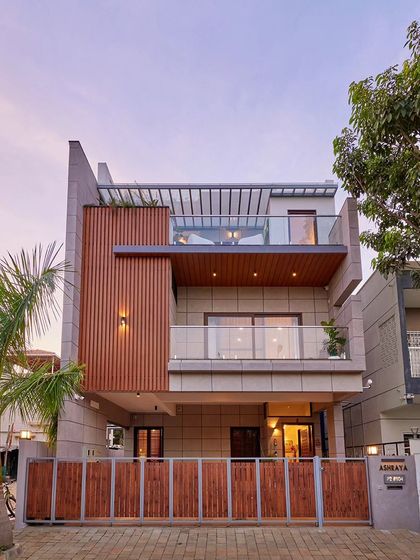 A daytime view of the Odion Woods villa. The contemporary elevation is treated with concrete texture paint and aluminum strip cladding, creating a simple and elegant look.