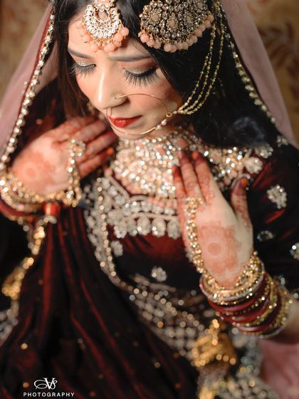 A detailed close-up of a Muslim bride, showcasing the craftsmanship of her jewelry and the rich texture of her velvet dress.