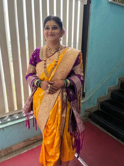 A full-length view of the bride, showing the perfect Nauvari saree draping that is essential for a traditional Maharashtrian wedding.