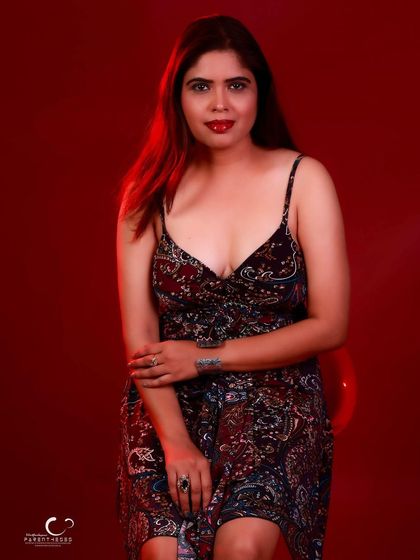 A calm and confident seated portrait. Her direct gaze and relaxed posture are inviting and engaging.