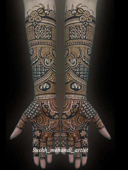 A full view of a complex bridal design against a black background, which makes the details pop. The names of the bride and groom are hidden within the patterns.