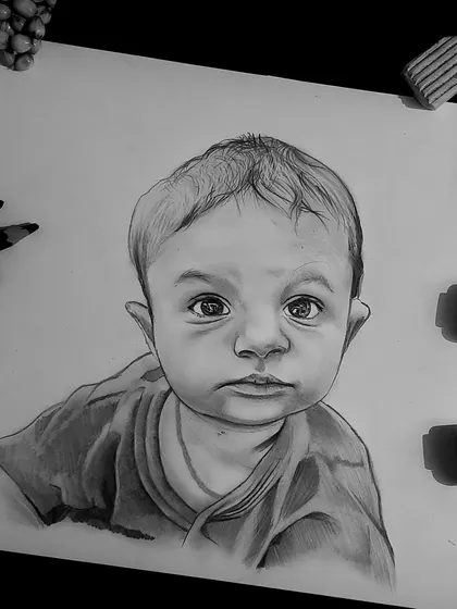 This A4 size baby portrait was created using graphite pencils. The image shows the finished sketch alongside the tools I use, giving a glimpse into my workspace.