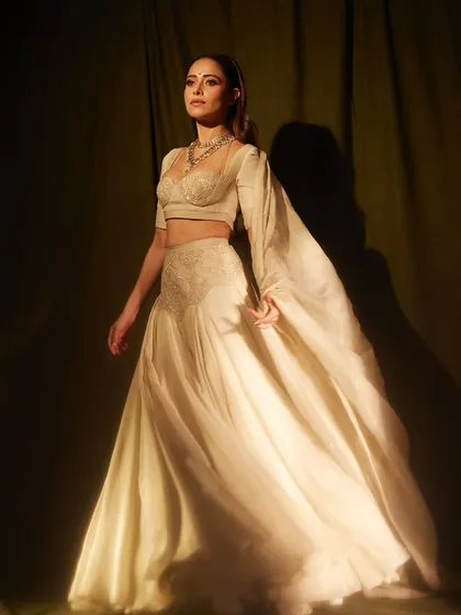 Here’s another ethereal ivory look for Nushrratt Bharuccha. This Manish Gharat lehenga with its unique blouse and flowing fabric is all about understated elegance and modern grace.