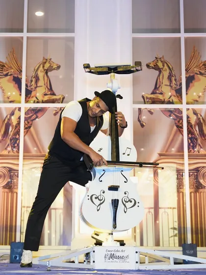 The cello performer in action, showcasing his strength and musicality in this one-of-a-kind act.