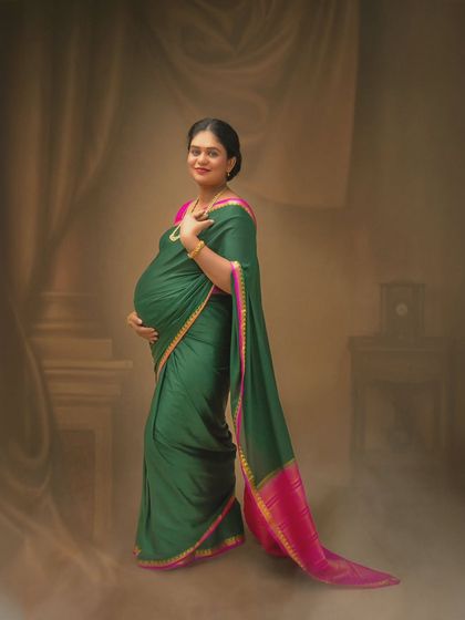 A simple yet elegant portrait focusing on the mother-to-be and her beautiful green saree. The soft, hazy background keeps all the attention on her joyful expression.