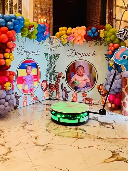 A 360-degree photo booth area for a jungle party, with personalized backdrops featuring the birthday twins' photos.