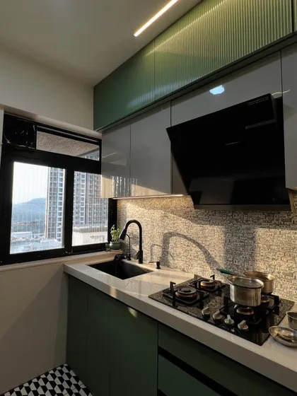 Sunlight streams into this kitchen, highlighting the beautiful mosaic backsplash, modern black fixtures, and sleek chimney.