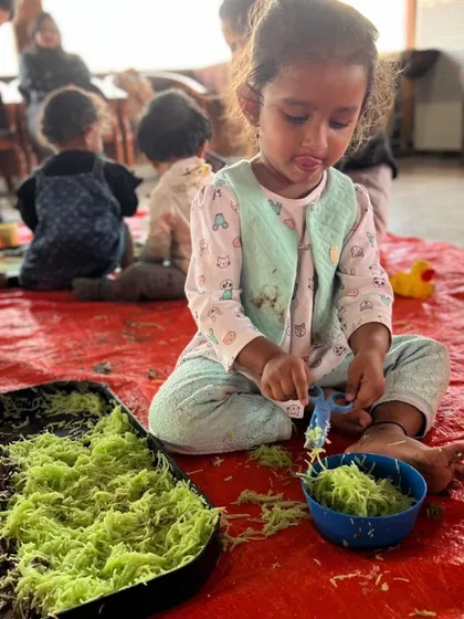 Using child-safe scissors to cut up spaghetti is an excellent way to strengthen hand muscles needed for writing later on. This little one is so focused on the task.