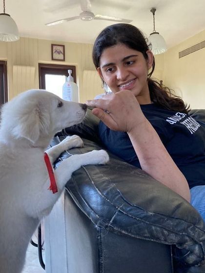 A gentle moment between a student and a fluffy white puppy. Teaching positive interaction is a key part of my courses.