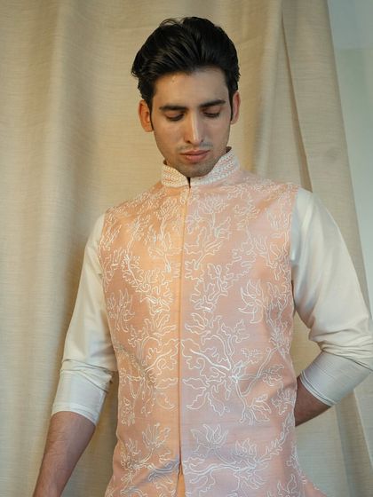 Elevate your style with our exquisite floral dori work on a peach silk jacket, designed to make a lasting impression.