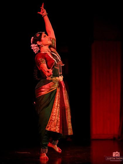 A pose reaching upwards, symbolizing an offering or a connection to the divine. Solo recitals often explore the spiritual dimensions of dance.