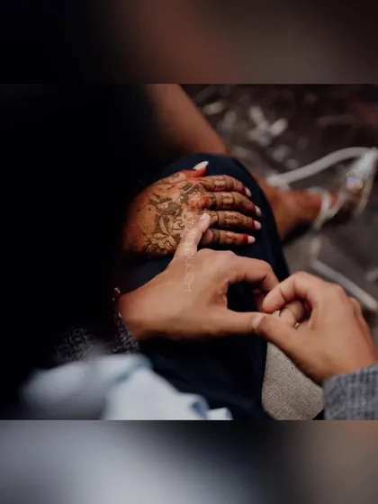 A sweet, candid moment captured during the mehendi application.