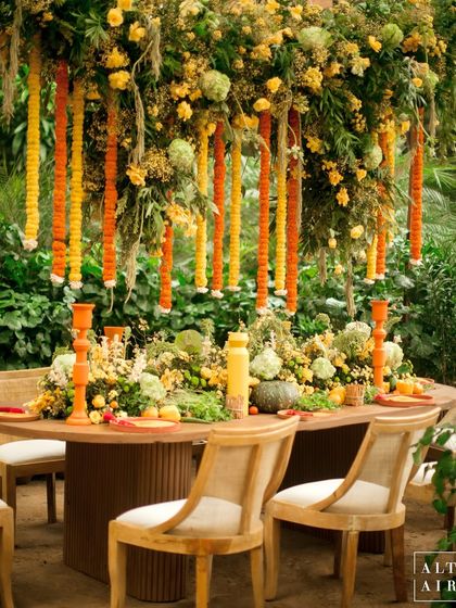 A stunning tablescape from the 'Kesar Sehar' Haldi, with a canopy of marigold garlands above. This ceremony was an ode to Indian art and culture, with a vibrant, modern approach.