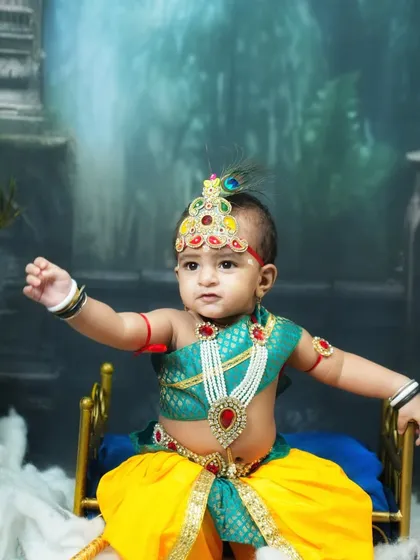 A close-up of our little Krishna, reaching out with a divine expression. The peacock feather crown and traditional jewelry are key elements of this popular theme.