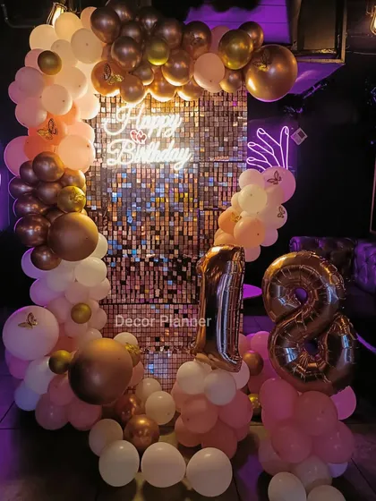The full setup for an 18th birthday, complete with foil number balloons. The warm tones of the rose gold create a welcoming and celebratory atmosphere in the club setting.