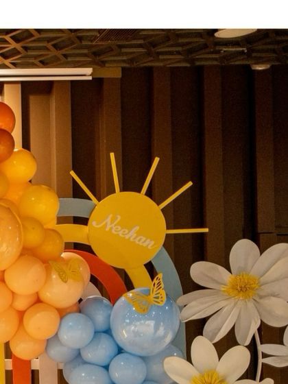 A 'Neehan' sun prop and large daisy cutouts add a personal and cheerful touch to this first birthday celebration.