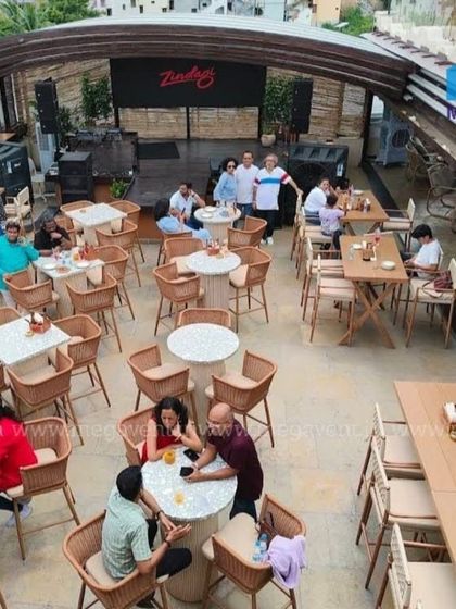 The same restaurant space with the retractable roof fully open. This demonstrates the system's flexibility, allowing guests to enjoy the open air and sunshine.