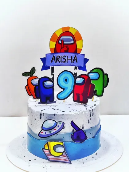 An "Among Us" theme cake that's perfect for fans of the popular game. The cake features colorful crewmate toppers and a space-themed design, all made with edible materials.