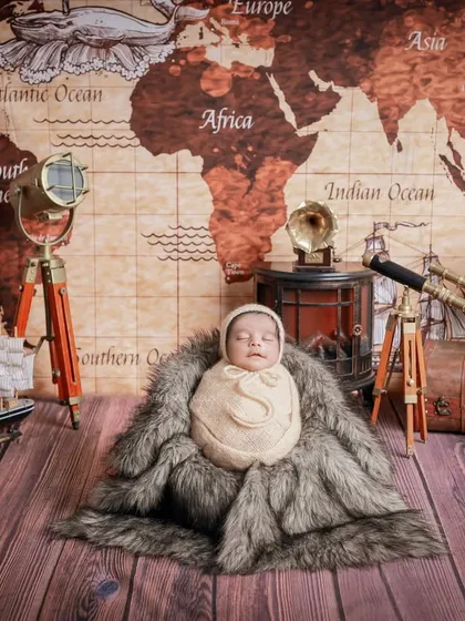 Our 'Little Traveler' theme, featuring a vintage world map, a telescope, and classic luggage. This setup is perfect for adventurous parents dreaming of future journeys with their baby.