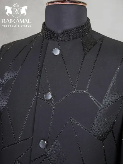 A close-up of the collar and button placket of the black geometric Jodhpuri, showing the texture of the beadwork.