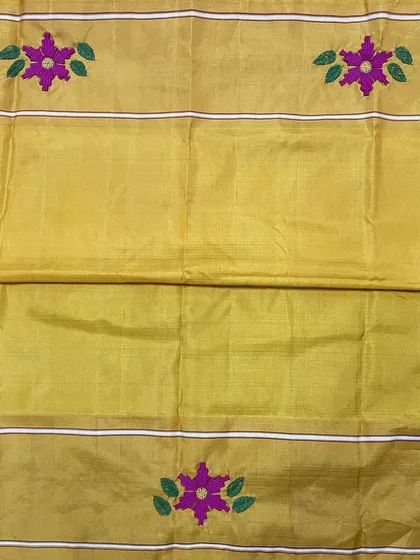 The body of the Kanjeevaram saree features scattered floral butis, hand-embroidered to match the intricate border. This technique adds a subtle richness to the entire length of the saree.