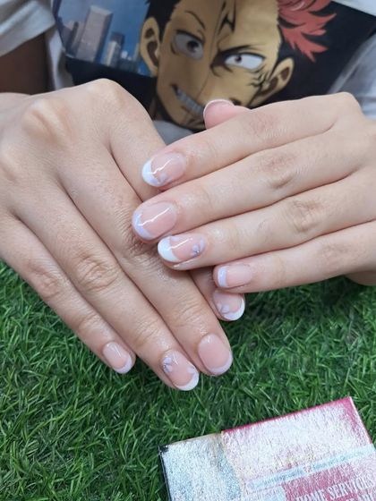 A beautiful example of a French manicure on natural nails, keeping them looking neat and elegant.