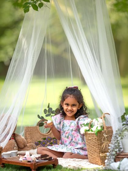 A dreamy picnic setup for a little princess. This whimsical tent and basket of flowers create the perfect backdrop for a magical kids' portrait session.