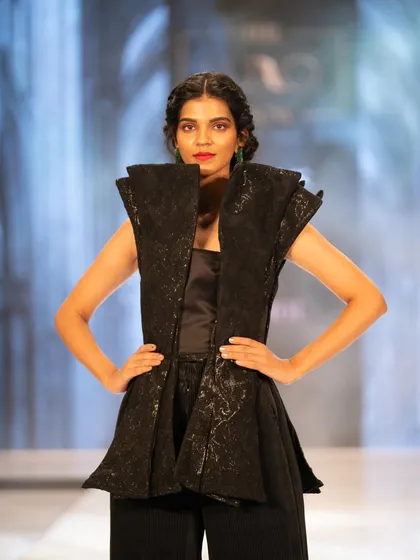 A powerful, structured look from The Luxo Show. The makeup is clean with a bold lip, matching the architectural design of the outfit.