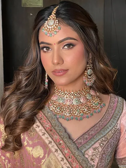 A close-up portrait showcasing the flawless soft glam makeup and the beautifully styled waves that frame her face.