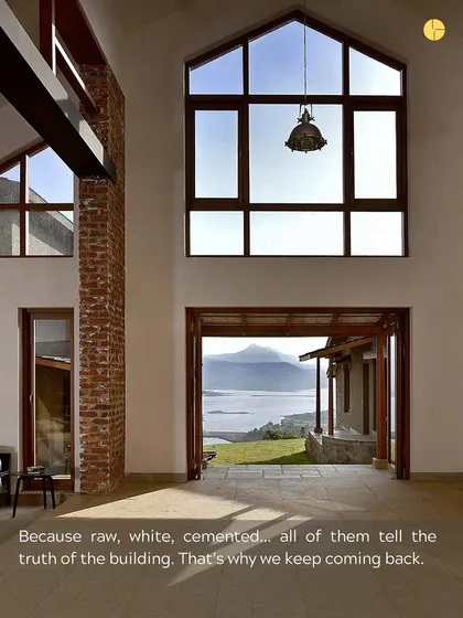 Raw, white, cemented... all of these materials tell the truth of the building. In this space, a large window frames a stunning natural view, while the exposed brick and white walls speak to the honesty of the construction.