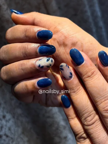 Nails you can’t stop staring at. This design combines a deep blue cat-eye polish with accent nails featuring a blue leopard print for a unique look.