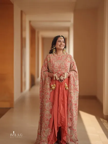 A full-length shot of Yashi's stunning Haldi outfit. The flowing cape and bright colors are perfectly complemented by a fresh and radiant makeup look.