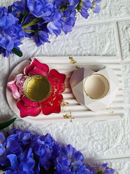 A stunning gypsum trinket tray styled with a pink floral T-light holder and a geometric candle holder. The gold leaf accents add a touch of luxury.