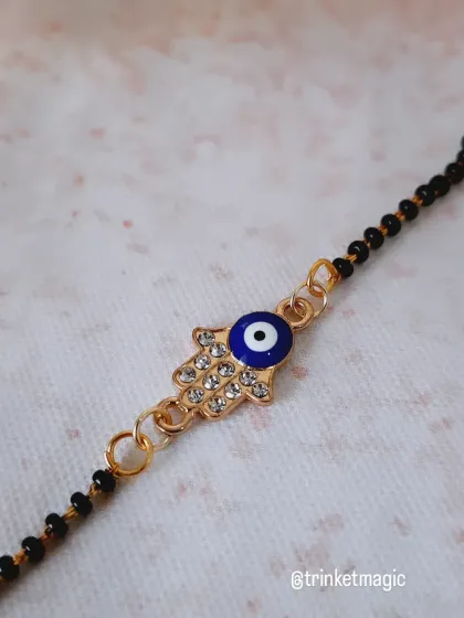 A close-up of the Hamsa hand evil eye charm. You can see the detailed stonework that adds a little sparkle to this protective bracelet.