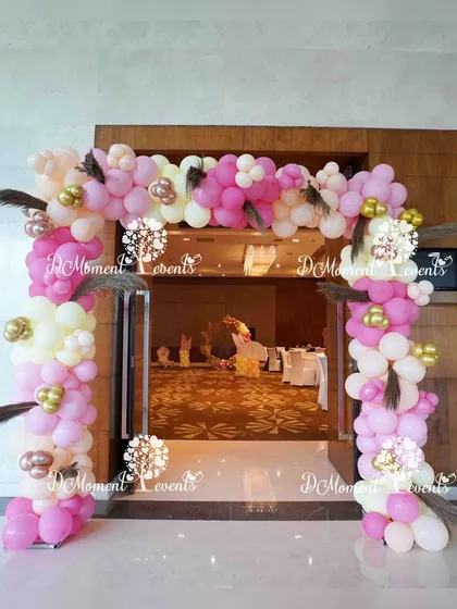 The entrance arch for the Boho Rainbow Annaprashan, featuring a lovely arrangement of pink and white balloons accented with delicate feathers.