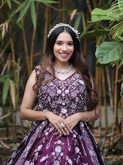 This wine-coloured ball gown is pure elegance, featuring intricate floral handwork across the bodice. Paired with a delicate tiara and necklace, it creates a regal look perfect for a bride's reception or a formal gala.