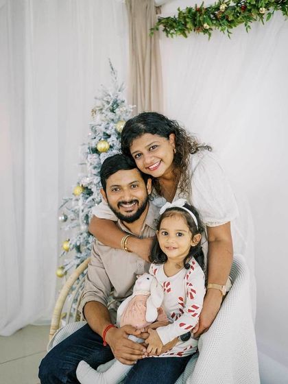 A beautiful family portrait in front of a white Christmas tree. The mother's hug and the daughter's sweet pose make this a lovely photo.