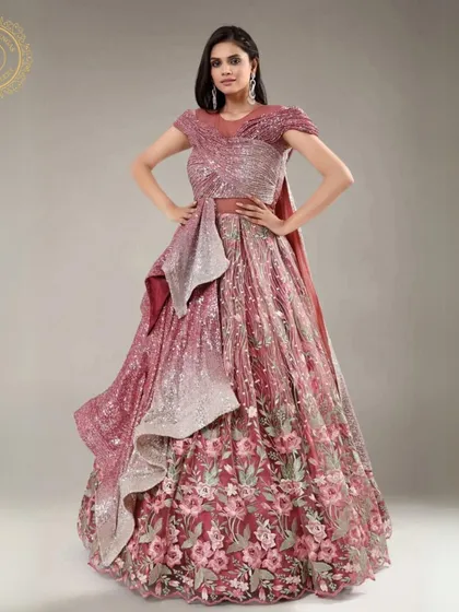 This designer gown features a unique silhouette with floral details and shimmering fabric. It's a high-fashion look available for rent.