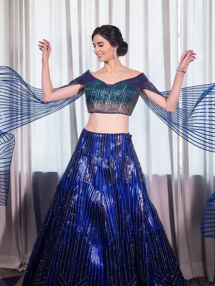 The dramatic, flowing sleeves of the lehenga add a touch of playfulness to this high-fashion look.