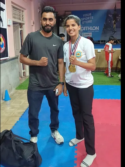 A coach stands proudly with one of our gold medal winners. This relationship between mentor and student is the foundation of our success, built on trust, hard work, and a shared passion for the sport.