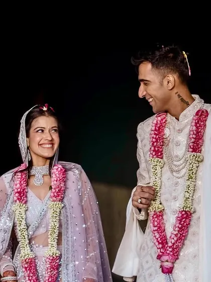 A joyful, candid moment between the bride and groom against a simple black background. The clean composition draws all attention to their smiles and the connection they share.
