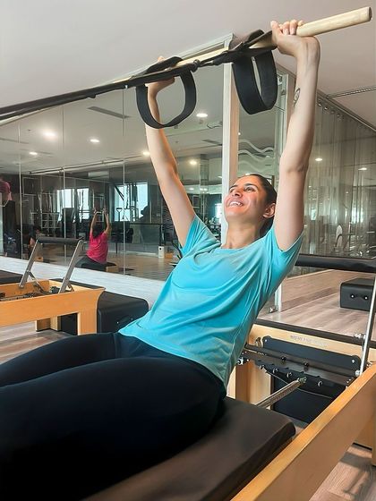That post Pilates glow. A client smiles after a challenging and rewarding session on the Reformer, feeling stronger and more balanced.